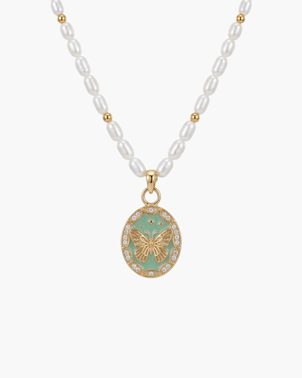 Macro view of a vintage gold butterfly relief pendant with a light green enamel base and zircon halo on a white pearl strand.
