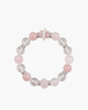 Top view of a pastel pink and clear crystal gemstone bracelet featuring large round beads, a carved pink quartz teddy bear, and tiny white pearls.