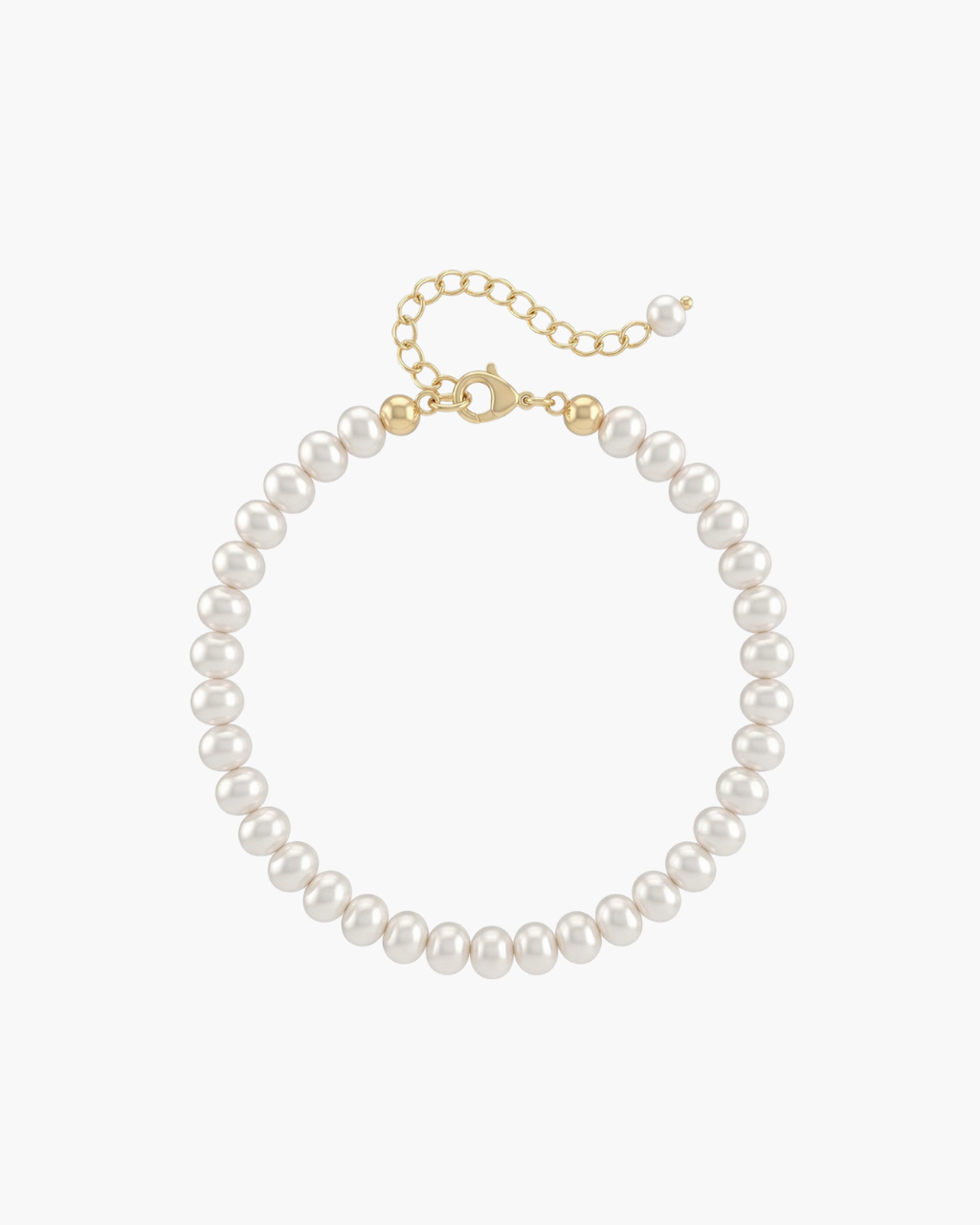 Top view of a delicate white pearl strand bracelet with gold lobster clasp and extension chain on a white porcelain dish.