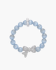 Top view of a shimmering icy blue cat-eye bead bracelet with a central sparkling silver bow charm and small pearl accents.